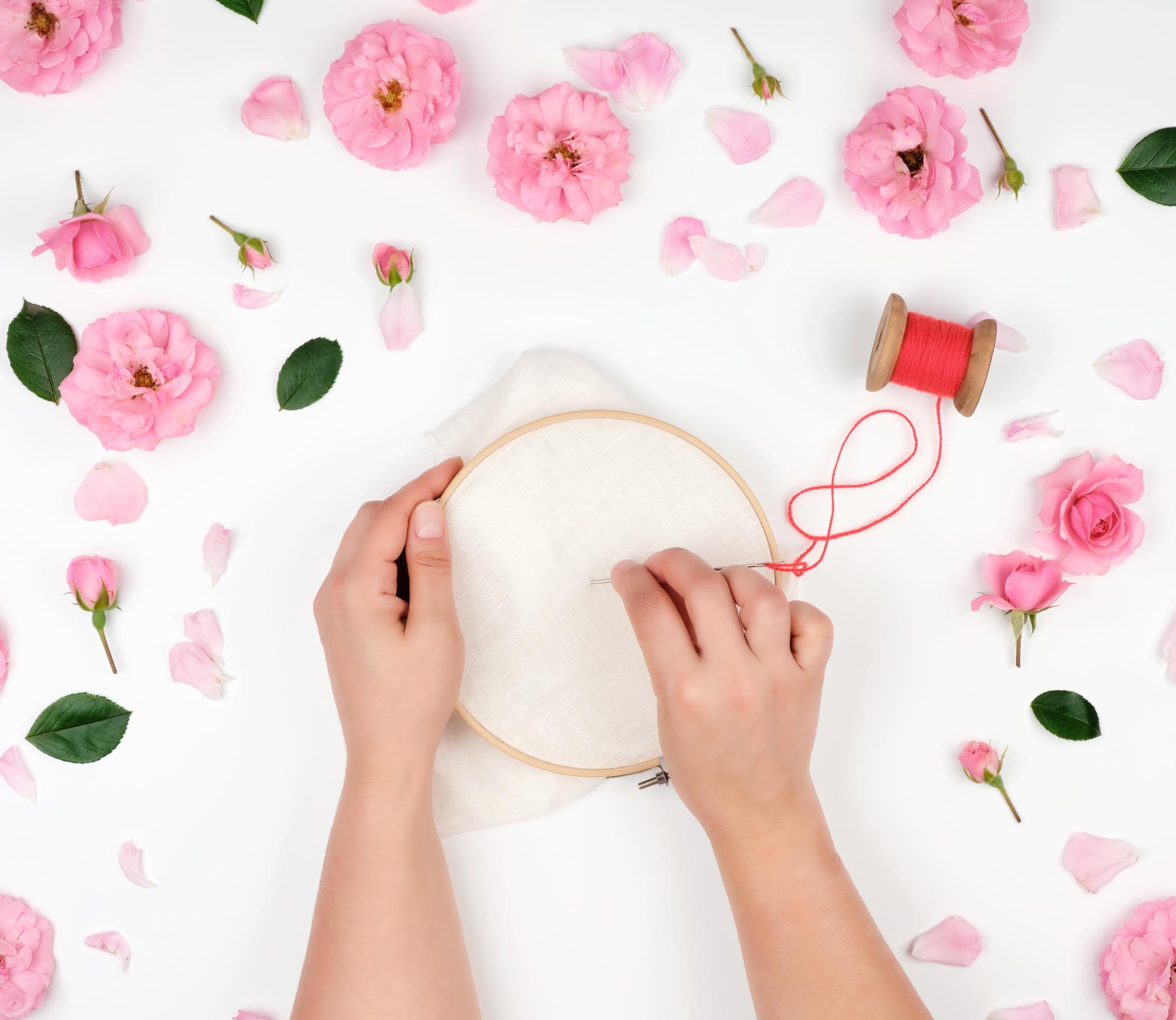 Artist stitching a floral motif